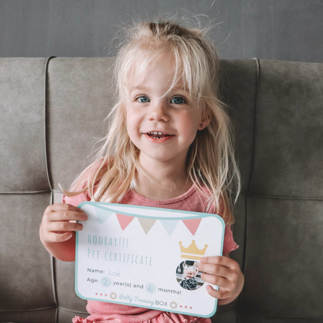 A girl holding up her finished pee certificate at the end of the week